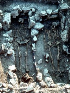 Zu Füßen der linken Toten (Grab 83) ist neben dem Holzeimer der Schädel eines etwa 1 Jahr alten Kindes zu erkennen.
