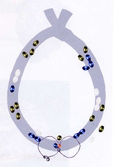 Kopfschmuck eines etwa dreijährigen Mädchens. Verschiedene Perlen wurden in Dreiergruppen auf einem Stoffband aufgenäht, wobei nur die hinteren Enden des Stoffs freiblieben. Das Zentrum schmückten zwei S-Schleifenringe, auf die je eine kleine Perle aufgeschoben war.